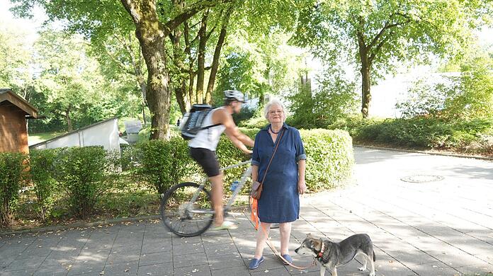 Gabriele Stieglbauer am Eingang zum Park östlich der Regina-Ullmann-Straße. Radler nutzen hier meistens den Gehweg. Eine klare Beschilderung fehlt. Als Fußgängerin fühlt sich die Seniorin mit ihrem Hund auf den engen Wegen daher sehr unwohl.