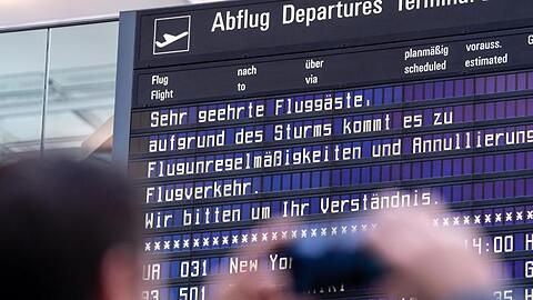 Ein Reisender fotografiert am Münchner Flughafen eine Anzeigetafel mit einem Hinweis. Foto: Matthias Balk/dpa