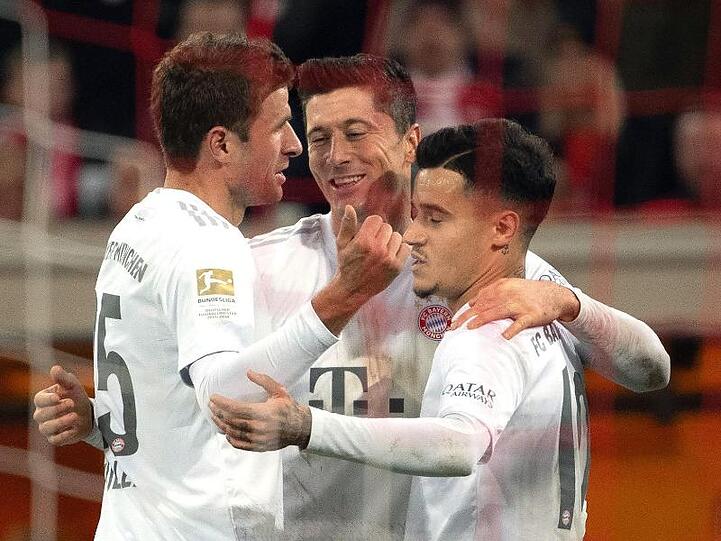 Die Münchner Thomas Müller (l), Philippe Coutinho (r) und Robert Lewandowski feiern das 4:0.