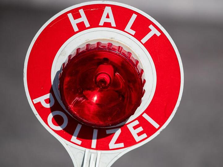 "Halt Polizei" steht auf einer Polizeikelle. Foto: Daniel Karmann/dpa/Archivbild