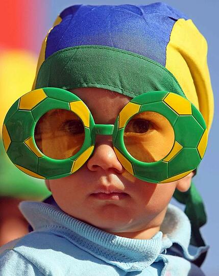 KINDERBRILLE: Tragen Kinder? Fehlanzeige. Bunte Plastikgestelle, gern gemustert, sitzen neuerdings auch auf erwachsenen Nasen. Botschaft: Ich bin kreativ, verspielt und würde gern zu Peter Pan nach Nimmerland ziehen, wo ich immer Kind bleiben darf. Für diesen brasilianischen Fußballfan ist das Modell aber genau das Richtige.