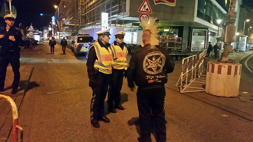 Ein Punk mit gelben Haaren will sich das Programm ganz aus der Nähe anschauen. An der Absperrung ist Schluss für ihn.