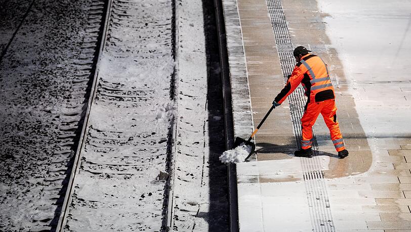 Ein Mann r&auml;umt am Hauptbahnhof in Hamburg auf einem Bahnsteig Schnee.