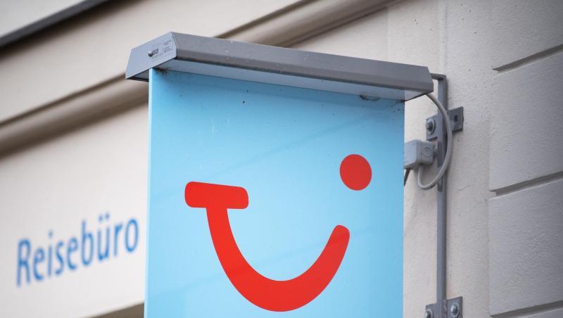 Das Logo des Reiseunternehmens TUI neben einem geschlossenen Reisebüro. Das Logo des Reiseunternehmens TUI neben einem geschlossenen Reisebüro.