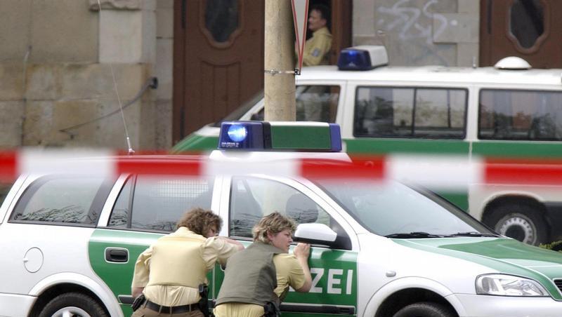 Polizeibeamte gegen hinter ihrem Wagen vor dem Gutenberg-Gymnasium in Erfurt in Deckung. (Archivfoto vom 26.04.2002) Polizeibeamte gegen hinter ihrem Wagen vor dem Gutenberg-Gymnasium in Erfurt in Deckung. (Archivfoto vom 26.04.2002)