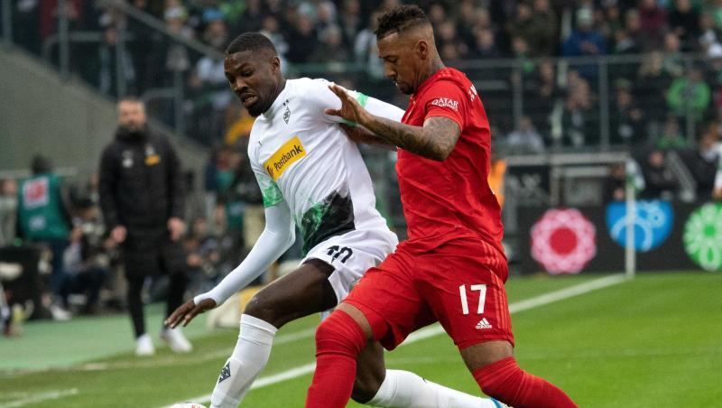 Gladbachs Marcus Thuram (l) und Bayerns Jerome Boateng versuchen den Ball zu spielen. Foto: Federico Gambarini/dpa Gladbachs Marcus Thuram (l) und Bayerns Jerome Boateng versuchen den Ball zu spielen. Foto: Federico Gambarini/dpa