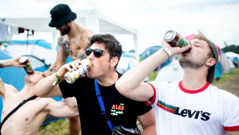 Drei junge Festivalbesucher versuchen sich im Synchron-Trinken. Drei junge Festivalbesucher versuchen sich im Synchron-Trinken.