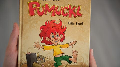 Eine Frau hält ein Pumuckl-Buch in den Händen.