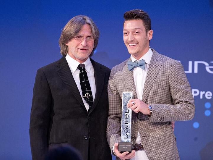 Trainer Norbert Elgert (l.) und Fußballer Mesut Özil bei einer Preisverleihung in Berlin. Foto: Jörg Carstensen/Archiv