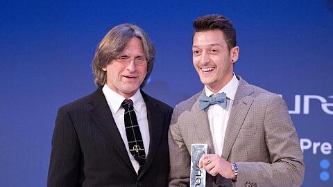 Trainer Norbert Elgert (l.) und Fußballer Mesut Özil bei einer Preisverleihung in Berlin. Foto: Jörg Carstensen/Archiv