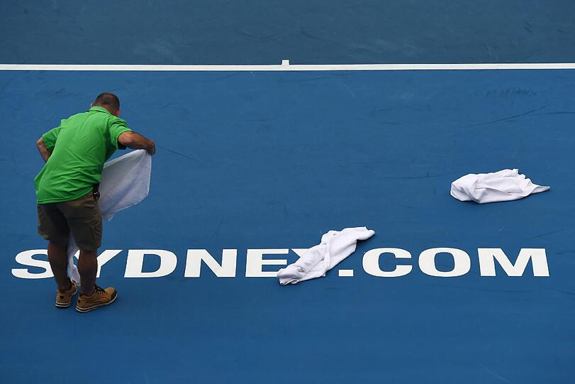 Unterbrechung in Sydney: Wegen heftiger Regenfälle wurden die Erstrunden-Matches der Australian Open unterbrochen. Hier trocknet ein Helfer den Platz nach einem Regenguss