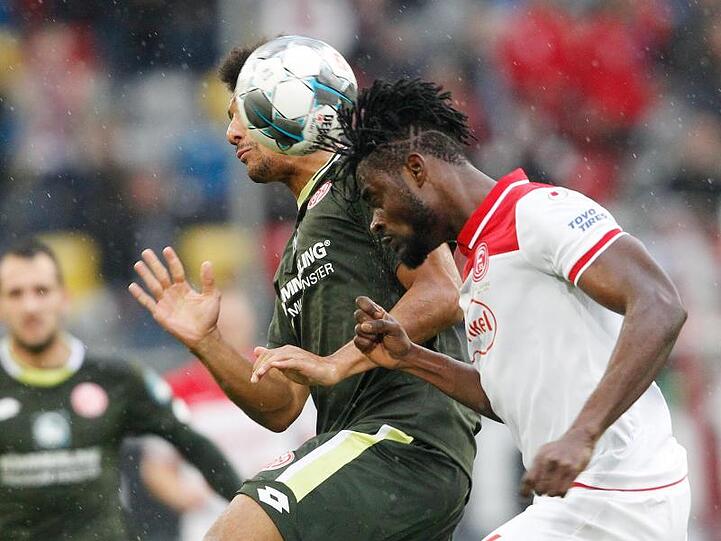 Der Düsseldorfer Kasim Adams (r) köpft vor dem Mainzer Karim Onisiwo den Ball.