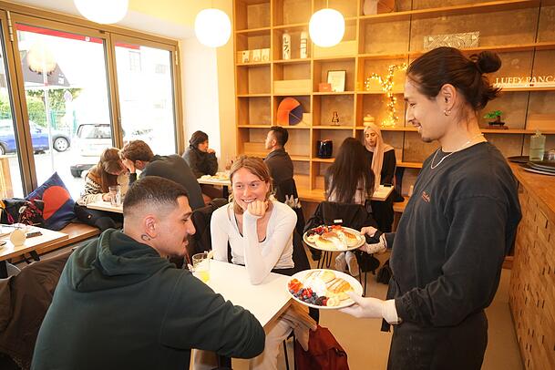 Servicecraft Keita Kawai (r.) bringt die Pancakes an den Tisch von Furkan (22) und Lilien (26). Servicecraft Keita Kawai (r.) bringt die Pancakes an den Tisch von Furkan (22) und Lilien (26).