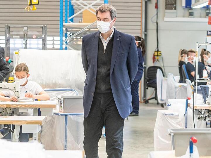 Markus Söder mit einer Mundschutzmaske in einer Produktionshalle des Automobilzulieferers Zettl. Foto: Armin Weigel/dpa