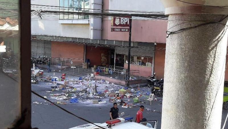 Polizisten untersuchen das Gelände vor einem Einkaufszentrum nach der Bombenexplosion. Polizisten untersuchen das Gelände vor einem Einkaufszentrum nach der Bombenexplosion.