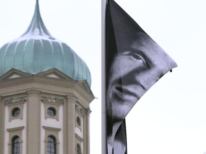 Eine Fahne wirbt vor dem Rathaus in Augsburg mit dem Portrait Bertolt Brechts für das Brechtfestival 2013. Foto: Karl-Josef Hildenbrand/dpa/Archivbild