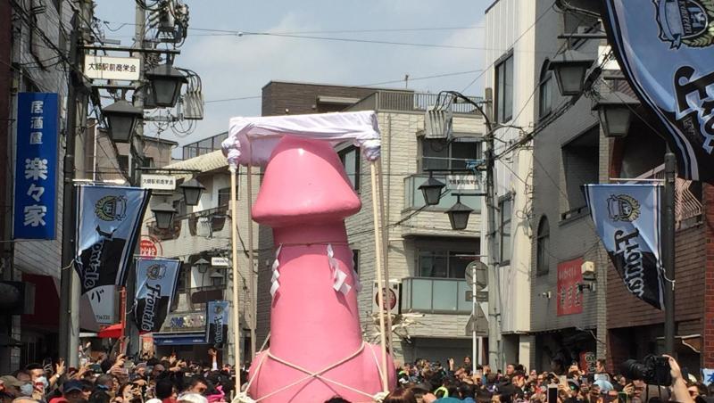 Ein riesiger Phallus wird beim Phallus-Festival in Kawasaki durch die Straßen getragen. Ein riesiger Phallus wird beim Phallus-Festival in Kawasaki durch die Straßen getragen.