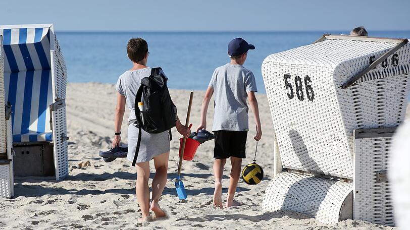 Urlauber sind vormittags am Strand von Hörnum unterwegs.