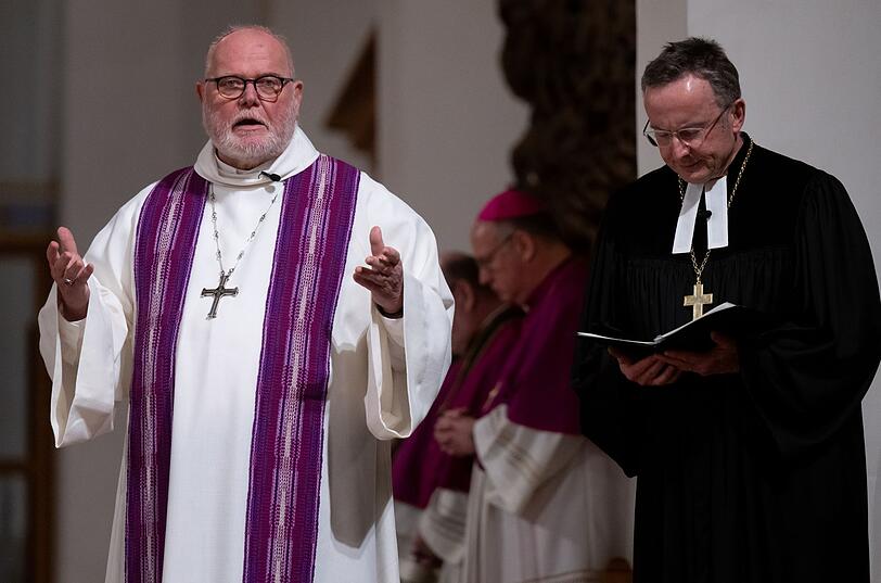 Christian Kopp (r.), Landesbischof der Evangelisch-Lutherischen Kirche in Bayern, und Kardinal Reinhard Marx, Erzbischof von München und Freising, in der Münchner Frauenkirche beten bei einem ökumenischen Gottesdienst für die Opfer des Münchner Anschlags.
