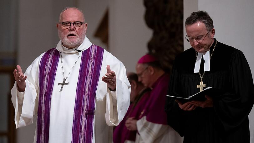 Christian Kopp (r.), Landesbischof der Evangelisch-Lutherischen Kirche in Bayern, und Kardinal Reinhard Marx, Erzbischof von München und Freising, in der Münchner Frauenkirche beten bei einem ökumenischen Gottesdienst für die Opfer des Münchner Anschlags.