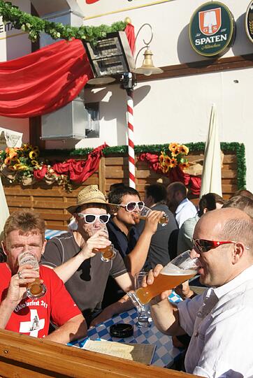 Eine Gruppe Schweizer genießt das erste Getränk im Weißbiergarten.