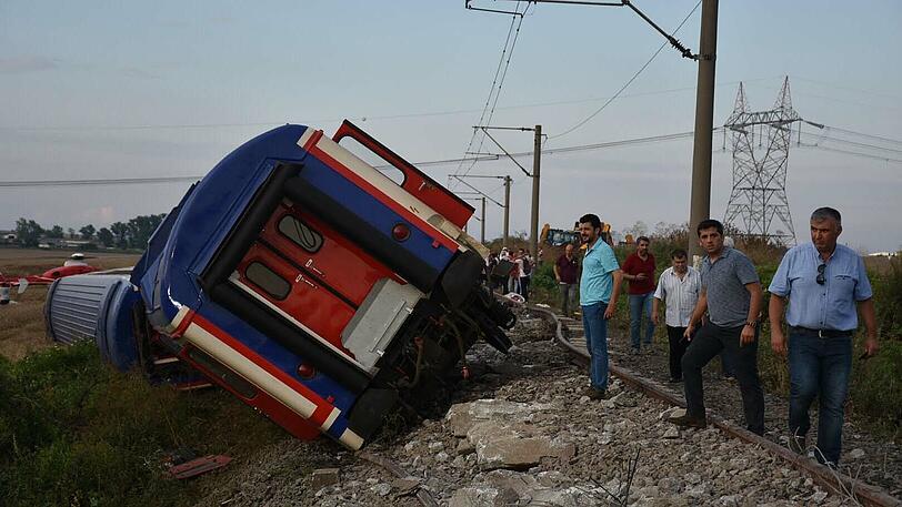 Menschen stehen neben einem entgleisten Zug in der Provinz Tekirdag.