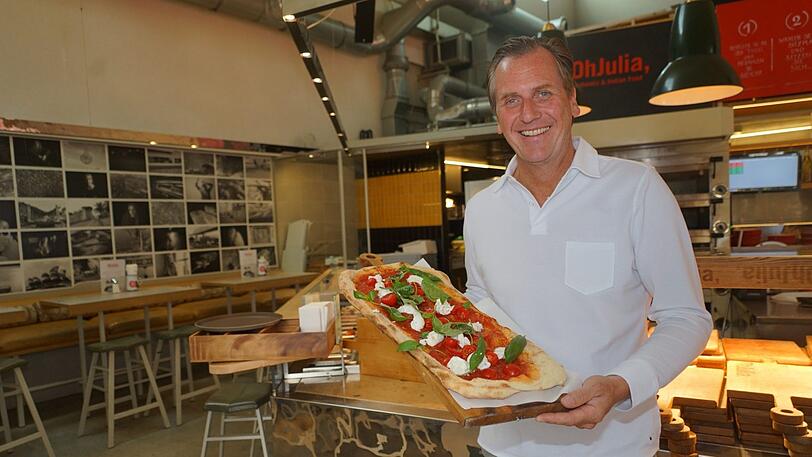 Marc Uebelherr in seinem Lokal "OhJulia": In seinen Händen hält er eine große Pizza Caprese (Preis: 23 Euro).