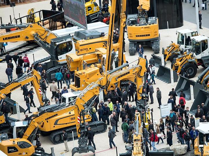 Viele Besucher gehen während der Baumesse Bauma über den Messestand der Firma "Liebherr". Foto: Sven Hoppe/Archiv
