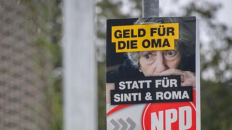 Ein Wahlplakat der NPD mit der Aufschrift "Geld für die Oma statt für Sinti und Roma" hängt am Straßenrand. Foto: Matthias Balk/Archivbild