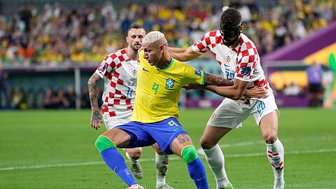 Brasiliens Richarlison (M) schirmt den Ball vor dem Kroaten Josko Gvardiol (r) ab.