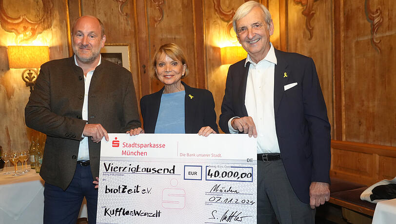 Sebastian Kuffler (links) übergibt im Spatenhaus einen Scheck über 40.000 Euro an Uschi Glas und ihren Mann Dieter Hermann. Die beiden können das Geld für ihren Verein Brotzeit e.V. gut gebrauchen.
