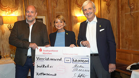 Sebastian Kuffler (links) übergibt im Spatenhaus einen Scheck über 40.000 Euro an Uschi Glas und ihren Mann Dieter Hermann. Die beiden können das Geld für ihren Verein Brotzeit e.V. gut gebrauchen.