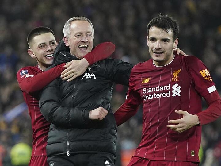 Liverpools U23-Coach Neil Critchley (M) jubelt mit Adam Lewis (l) und Pedro Chirivella (r) über den Einzug ins Achtelfinale.