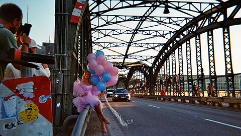 Der Obdachlose Johan fotografierte diese Szene an der Hackerbrücke. Gerade posiert dort das Model Melinda (Instagram: melinda.prade) in einem märchenhaften Kleid mit Ballons für ein Shooting. Dieser Moment vor der prunkvollen Brückenkonstruktion habe ihn sehr berührt, sagt er.