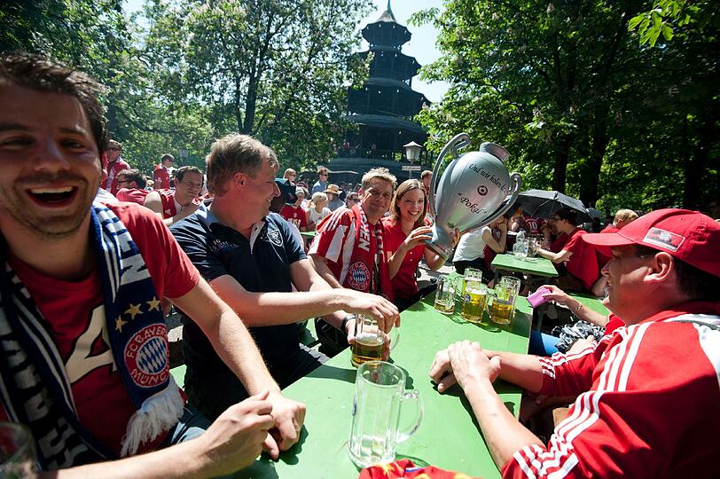 Mit dem Pokal in den Biergarten. Diese Fans bereiten sich bei strahlendem Sonnenschein auf die echte Pokaljagd vor. Auf die Bayern!