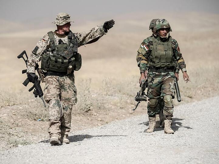 Ein Bundeswehrsoldat und kurdische Peshmerga im irakischen Erbil.
