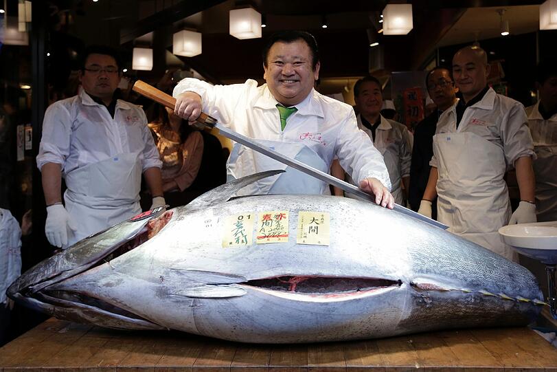 Kiyoshi Kimura, Vorsitzender der größten japanischen Sushi-Kette, präsentiert einen 200kg schweren Thunfisch, der für umgerechnet 117000 US-Dollar versteigert wurde.