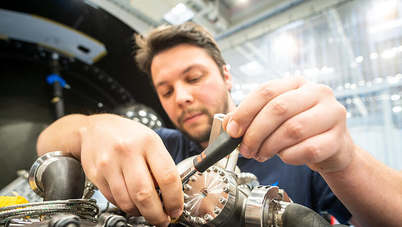 Ein Mitarbeiter setzt eine Rakete zusammen. Die Feinarbeit muss weiterhin von Menschen erledigt werden, nicht von Robotern.