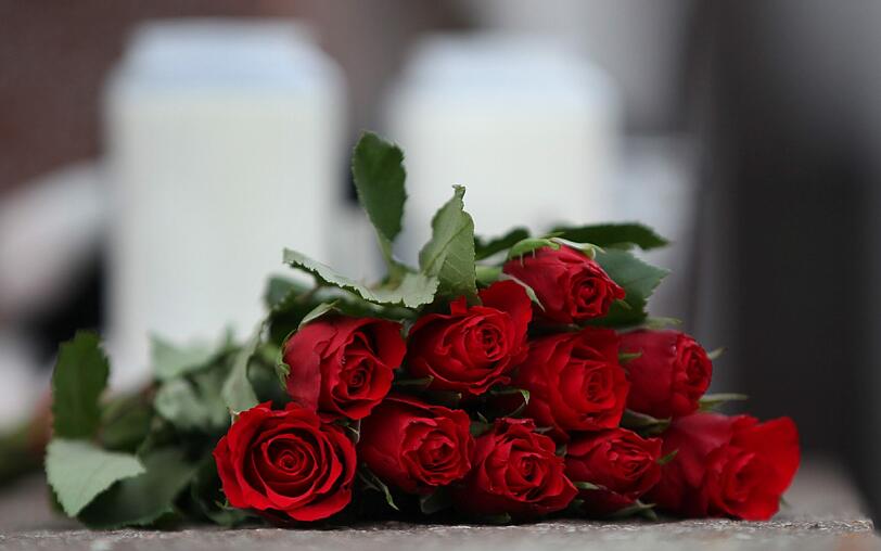 Rote Rosen, Kerzen und Kuscheltiere liegen vor dem Haus, in dem die kleinen Mädchen starben.