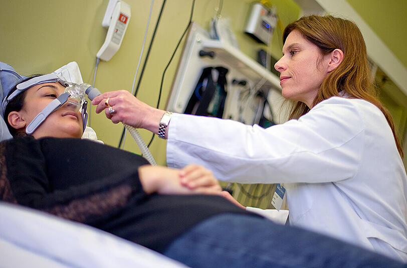 Die Oberärztin und Leiterin des Schlaflabors im Klinikum Nürnberg , Dora Triche, demonstriert an einer Mitarbeiterin die Anbringung einer CPAP-Maske zur Behandlung von Schlaf-Apnoe.