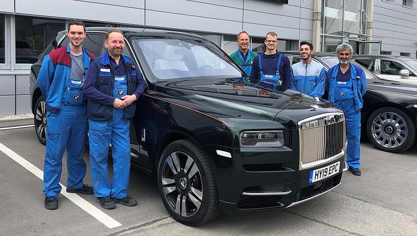 Daniel (v.l.) und Andi mit weiteren Werksmitarbeitern in Unterhollerau neben einem Cullinan. Sie fertigen die Karosserien sämtlicher Rolls-Royce-Modelle.