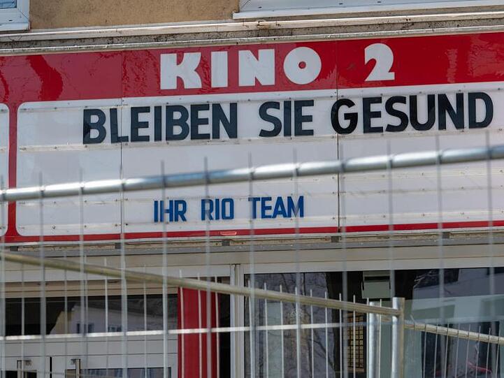 "Bleiben sie gesund" steht über dem Eingang eines geschlossenen Kinos im Bezirk Haidhausen in München. Foto: Peter Kneffel/dpa/Archivbild