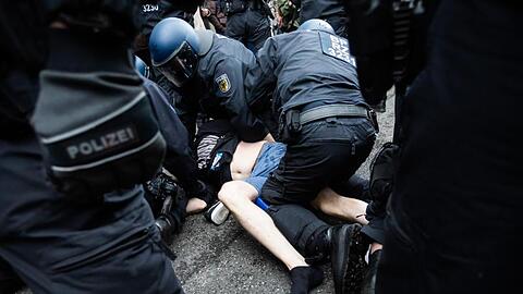 Polizisten nehmen bei einer Kundgebung gegen die Corona-Maßnahmen nahe dem Potsdamer Platz einen Mann fest.