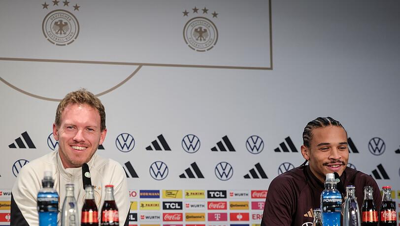 Bundestrainer Julian Nagelsmann (l) und Leroy Sané sprechen auf der Abschlusspresskonferenz im Olympiastadion.
