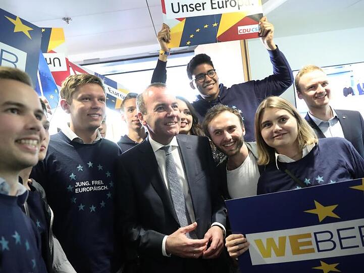 Der Spitzenkandidat der Union, Manfred Weber steht mit Anhängern zusammen. Foto: Michael Kappeler
