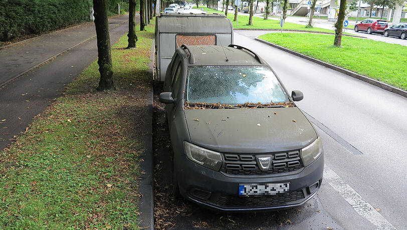 Dieser Dacia mit Wohnwagen-Anhänger steht schon monatelang unter einer Linde. Dieser Dacia mit Wohnwagen-Anhänger steht schon monatelang unter einer Linde.