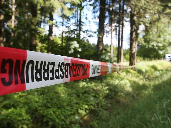 Ein Absperrband der Polizei umzäunt ein Waldstück. Foto: Bodo Schackow/Archiv