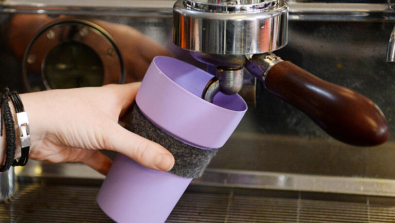 Ein Mehrweg-Kaffeebecher wird in einem Café gefüllt. (Symbolbild)
