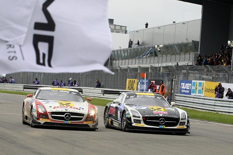Der Mercedes SLS des Teams Black Falcon (l) fährt am 20.05.2013 mit Bernd Schneider, Jeroen Bleekemolen Sean Edwards und Nicky Thiim auf dem Nürburgring bei Nürburg (Rheinland-Pfalz) als Sieger über die Ziellinie.