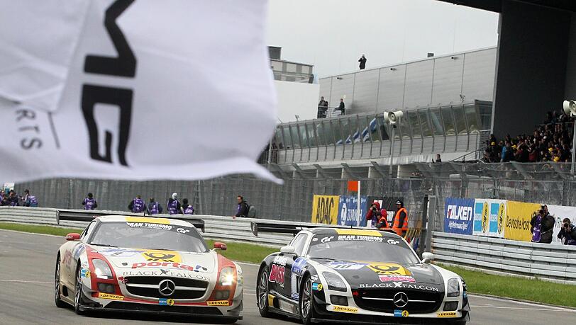 Der Mercedes SLS des Teams Black Falcon (l) fährt am 20.05.2013 mit Bernd Schneider, Jeroen Bleekemolen Sean Edwards und Nicky Thiim auf dem Nürburgring bei Nürburg (Rheinland-Pfalz) als Sieger über die Ziellinie.